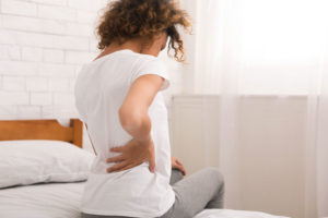 woman in bed with sciatica back pain