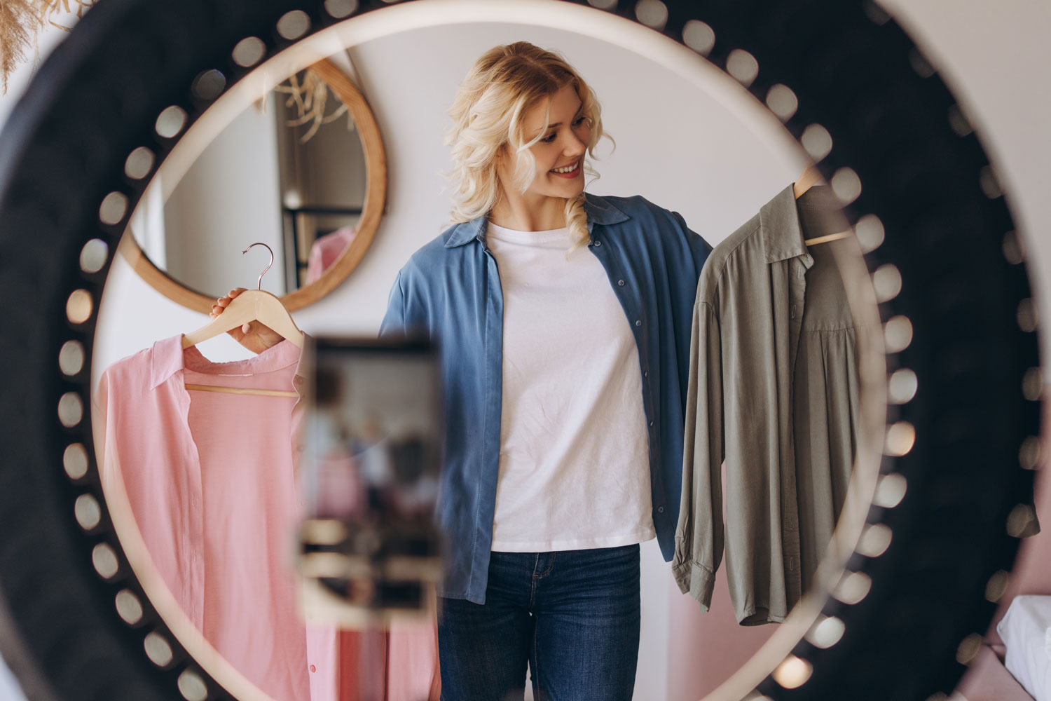 woman holding two shirts deciding what to wear